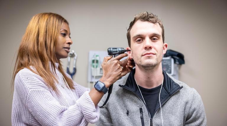 杜肯学生住院医师在检查病人的耳朵